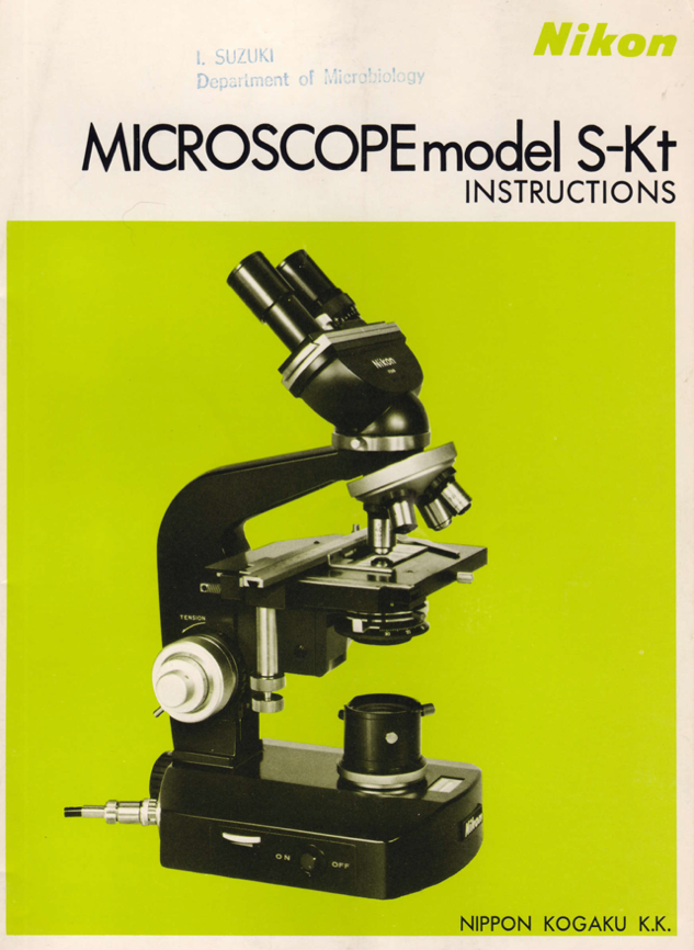 A black microscope with a green background
Description automatically generated
