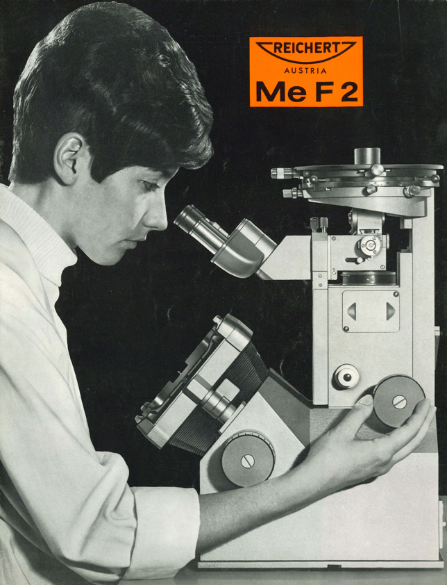 A person looking through a microscope
Description automatically generated