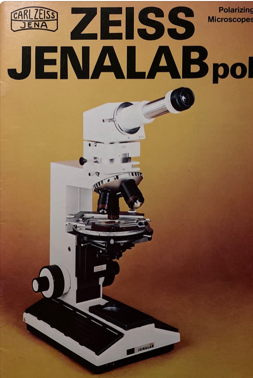 A white microscope on a yellow background
Description automatically generated